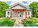 Inviting home with light siding, covered front porch, and lush landscaping at 322 S Hill St, Gastonia, NC 28052