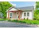 Quaint home exterior with a cozy front porch, verdant lawn, and established landscaping at 322 S Hill St, Gastonia, NC 28052