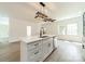 Bright, updated kitchen features island with quartz countertop, stainless appliances, and modern lighting at 322 S Hill St, Gastonia, NC 28052