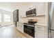 Updated kitchen features stainless steel appliances, white cabinets, and quartz countertops at 322 S Hill St, Gastonia, NC 28052