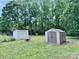 Spacious backyard featuring two storage sheds for all your organizational needs, set in a grassy, tree-lined landscape at 341 Austin Dr, York, SC 29745