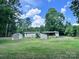 Expansive backyard featuring various outbuildings, surrounded by green space, and backing to a private wooded area at 341 Austin Dr, York, SC 29745