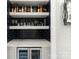 Modern bar area with sleek shelving, under-counter refrigerator, and stylish backsplash at 400 Hunter Ln, Charlotte, NC 28211