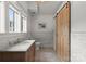 Bright bathroom featuring a marble vanity, subway tile, decorative rug and wooden barn door at 400 Hunter Ln, Charlotte, NC 28211