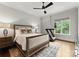 Cozy bedroom with hardwood floors, queen bed, ceiling fan, and a treadmill near the window at 400 Hunter Ln, Charlotte, NC 28211