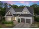 Charming home showcasing stone accents, a manicured lawn, a brick walkway and a two-car garage at 400 Hunter Ln, Charlotte, NC 28211