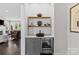 Stylish bar area with wine fridge, custom shelves, and decorative accents at 4030 City Homes Pl, Charlotte, NC 28209