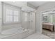 Luxurious bathroom featuring a soaking tub, glass-enclosed shower, and marble tile at 4030 City Homes Pl, Charlotte, NC 28209
