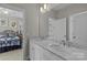 Bright bathroom showcasing double vanity, large mirror, and doorway to adjacent bedroom at 4030 City Homes Pl, Charlotte, NC 28209