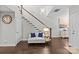 Elegant living area featuring a staircase, white couch with blue pillows, and stylish decor at 4030 City Homes Pl, Charlotte, NC 28209