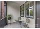 Cozy patio space featuring a small round table, decorative chairs, and large windows with white shutters at 4030 City Homes Pl, Charlotte, NC 28209