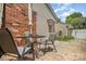 A cozy backyard patio with a brick wall, an umbrella, and a metal table and chairs at 4100 Sudbury Rd, Charlotte, NC 28205