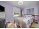 A cozy bedroom with hardwood floors, two windows, and light purple walls at 4100 Sudbury Rd, Charlotte, NC 28205