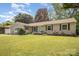 Inviting home featuring a well-maintained lawn, a front porch, and a sliding glass door entrance at 4100 Sudbury Rd, Charlotte, NC 28205