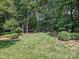 Manicured backyard with lush green lawn, well-maintained landscaping, and a serene seating area at 4608 Morrowick Rd, Charlotte, NC 28226