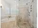 Bright bathroom with a soaking tub, walk-in shower, and neutral tile at 4608 Morrowick Rd, Charlotte, NC 28226