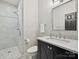 Modern bathroom featuring a marble countertop, glass shower, and patterned wallpaper at 4608 Morrowick Rd, Charlotte, NC 28226