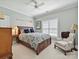 Comfortable bedroom featuring a wooden bed frame, ceiling fan and a cozy chair near the window at 4608 Morrowick Rd, Charlotte, NC 28226