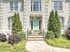 Inviting front entrance with a light blue door, stone walkway, manicured landscaping, and detailed architectural elements at 4608 Morrowick Rd, Charlotte, NC 28226