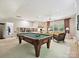 Spacious game room featuring a pool table, built-in bookshelves, and a comfortable seating area at 4608 Morrowick Rd, Charlotte, NC 28226