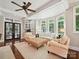 Bright living room featuring a ceiling fan, large windows, and comfortable seating arrangement at 4608 Morrowick Rd, Charlotte, NC 28226