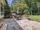 This patio features an outdoor kitchen with stone pavers and stainless steel grill, perfect for outdoor entertaining at 4608 Morrowick Rd, Charlotte, NC 28226