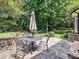 This patio features a stone paver surface, an umbrella shaded table, and seats, perfect for outdoor dining at 4608 Morrowick Rd, Charlotte, NC 28226