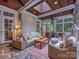 Inviting sunroom featuring a wooden ceiling, comfortable seating, and a view of the outdoors at 4608 Morrowick Rd, Charlotte, NC 28226