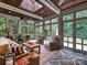 Cozy sunroom with a wood-paneled ceiling, ample seating, and large windows overlooking the garden at 4608 Morrowick Rd, Charlotte, NC 28226