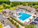 Birds eye view of a community pool, clubhouse, and parking area surrounded by mature trees and a golf course at 4609 Rounding Run Rd, Charlotte, NC 28277