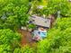 An aerial view of a home with a pool and deck partially obscured by mature trees at 4609 Rounding Run Rd, Charlotte, NC 28277