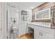 Stylish bathroom features a modern vanity with makeup counter, elegant backsplash, and tiled floors at 4609 Rounding Run Rd, Charlotte, NC 28277