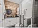 Modern bathroom boasts a wood-paneled wall, vessel sink, tiled shower, and sleek fixtures at 4609 Rounding Run Rd, Charlotte, NC 28277