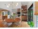 Bright dining room with modern chandelier, wood floors, and built-in bar, open to the living area with stone fireplace at 4609 Rounding Run Rd, Charlotte, NC 28277