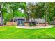 Beautiful home with stone accents, a green lawn, mature trees, and a welcoming driveway, creating a serene setting at 4609 Rounding Run Rd, Charlotte, NC 28277