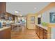 Open kitchen with wooden cabinets, granite countertops, stainless steel appliances, butcher block island, and hardwood floors at 4609 Rounding Run Rd, Charlotte, NC 28277