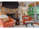 Comfortable living room featuring a stone fireplace, cozy seating, and a large window with outdoor views at 4609 Rounding Run Rd, Charlotte, NC 28277