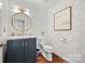 Chic powder room with modern vanity, designer wallpaper, a round mirror, and stylish fixtures at 4609 Rounding Run Rd, Charlotte, NC 28277