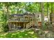 Multi-level house with a deck, wooden stairs, and lush green surroundings at 50 Honeysuckle Woods, Lake Wylie, SC 29710