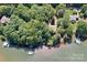 Stunning lakefront property featuring lush trees, boat docks, and serene water views from above at 505 Kemp Rd, Mooresville, NC 28117