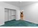 Cozy bedroom with closet, carpet, and an open doorway to the kitchen at 505 Kemp Rd, Mooresville, NC 28117