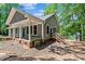 Charming home exterior with a covered porch and wooden stairs, nestled among lush trees at 505 Kemp Rd, Mooresville, NC 28117