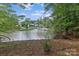 Scenic view of a house, lake, and boat dock framed by lush greenery at 505 Kemp Rd, Mooresville, NC 28117