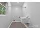 Well-lit laundry room featuring a utility sink and tile floor at 505 Kemp Rd, Mooresville, NC 28117