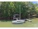 Waterfront view featuring a sailboat docked alongside a charming boathouse and pier at 505 Kemp Rd, Mooresville, NC 28117