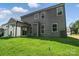 Expansive green backyard with a house featuring gray siding, many windows, and a covered patio at 5103 Heathland Dr # 50, Charlotte, NC 28215