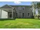 An expansive backyard with a view of a house with gray siding and a covered patio area on a lush green lawn at 5103 Heathland Dr # 50, Charlotte, NC 28215