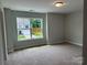 Bright bedroom with neutral walls and carpet and a large window offering outdoor views at 5103 Heathland Dr # 50, Charlotte, NC 28215