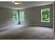 Spacious bedroom featuring three large windows with natural light and plush carpeting at 5103 Heathland Dr # 50, Charlotte, NC 28215