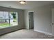 Bright bedroom with a window view, neutral carpet, and a fresh coat of paint at 5103 Heathland Dr # 50, Charlotte, NC 28215